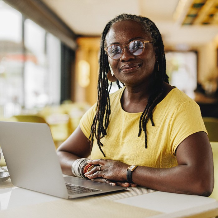 Woman smiling while working on laptop