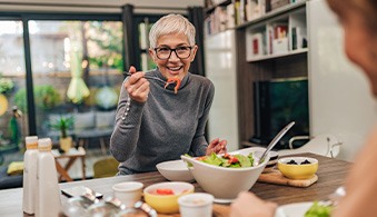 Woman smiling while eating lunch with friend